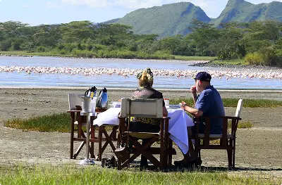 Couple enjoying a private outdoor dining safari experience by the water